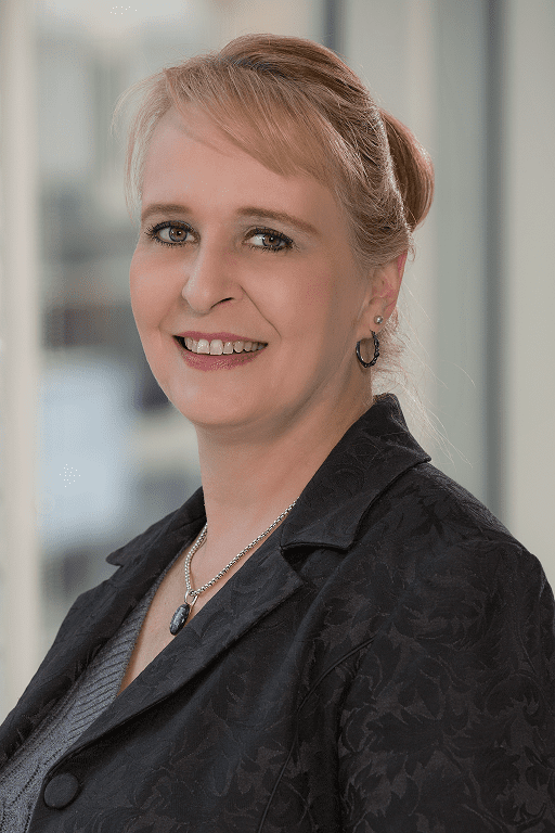 A woman in black jacket smiling for the camera.