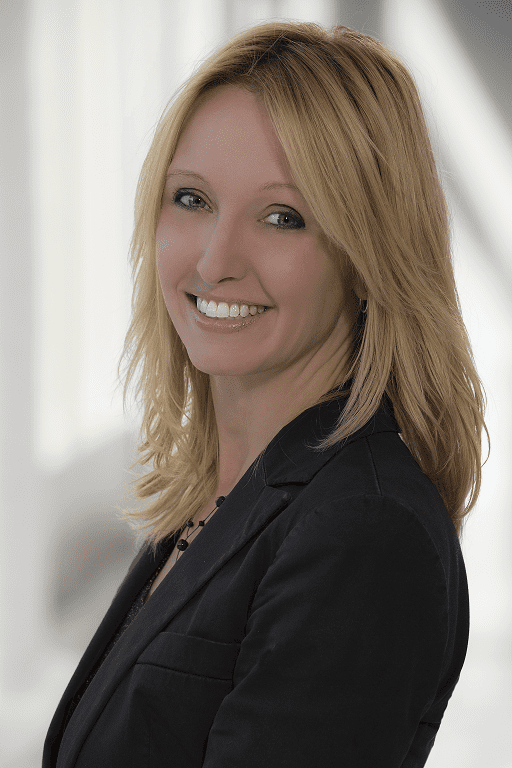 A woman in black jacket smiling for the camera.